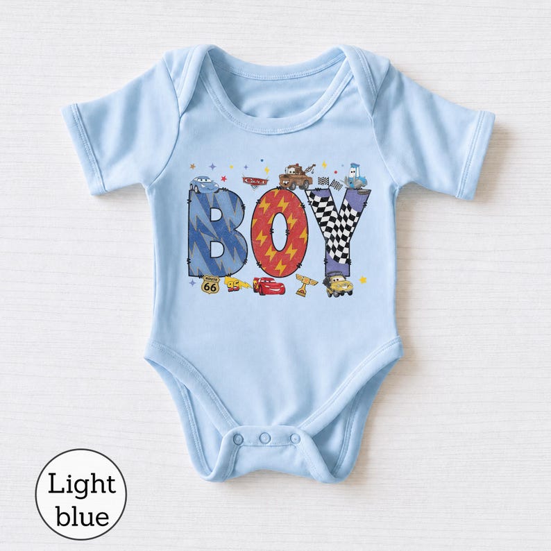 May include: A light blue short-sleeve bodysuit featuring the word BOY in large letters. The B is blue with lightning bolts, the O is red with lightning bolts, and the Y is black and white checkered. Characters from the movie Cars are included.