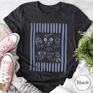May include: A charcoal gray short-sleeve t-shirt featuring a light blue graphic print of Disney character faces including Mickey Mouse, Minnie Mouse, Donald Duck, Daisy Duck, Goofy, and Pluto, with their names written below each character.