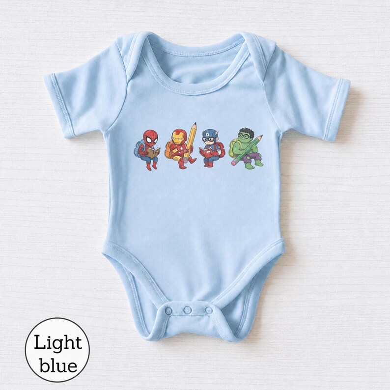 May include: A light blue short-sleeve bodysuit featuring a graphic print of four cartoon superheroes. The characters include Spider-Man reading a book, Iron Man holding a large pencil, Captain America reading, and the Hulk holding a pencil.