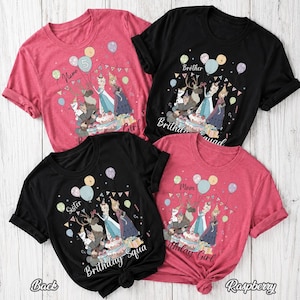 Op de afbeelding: Vier T-shirts met korte mouwen in framboos en zwart, elk met een grafische print van geanimeerde figuren, ballonnen en een verjaardagstaart. De tekst op de shirts bevat woorden zoals Name, Birthday Girl, Brother, Sister en Mom.
