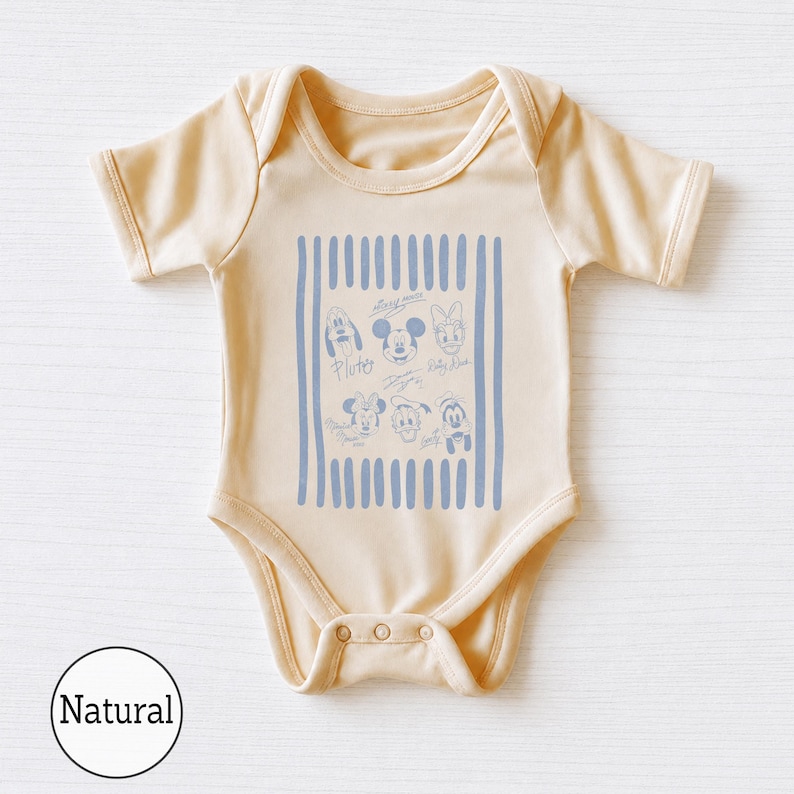 May include: A short-sleeved baby bodysuit in a light beige color. The center features a rectangular graphic with vertical blue stripes and line-art illustrations of Disney characters including Mickey Mouse, Minnie Mouse, Pluto, Donald Duck, and Daisy Duck.
