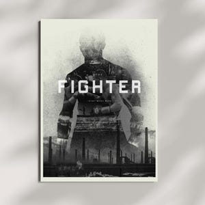 Op de afbeelding: Een zwart-wit poster met een dubbelbelichtingsontwerp. Het silhouet van een bokser bevat een afbeelding van twee vechters in een ring. De tekst THE FIGHTER staat in het midden in het wit, met IRISH MICKY WARD eronder boven een industrieel landschap.