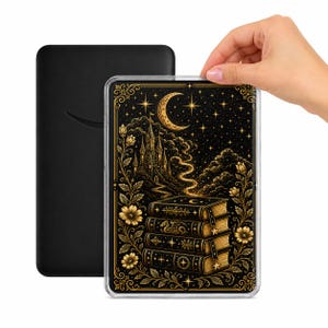 Op de afbeelding: Zwarte e-reader hoes met een fantasieontwerp. De hoes heeft een stapel boeken, een kasteel, een maan en sterren in goud op een zwarte achtergrond. Bloemenaccenten omlijsten het ontwerp. De e-reader wordt door een hand vastgehouden.