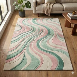 Könnte beinhalten: Ein rechteckiger Teppich mit einem wellenförmigen, fließenden Muster aus abwechselnden pastellrosa, salbeigrünen und cremefarbenen Streifen. Das Design besteht aus geschwungenen, strukturierten Linien, die eine Bewegung auf der Teppichoberfläche erzeugen.