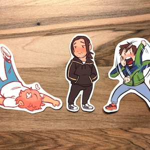 May include: Three cartoon stickers featuring male figures in various poses. One sticker shows a figure lying on the ground with their legs in the air. Another shows a figure standing with their hands in their pockets. The third sticker shows a figure throwing something.