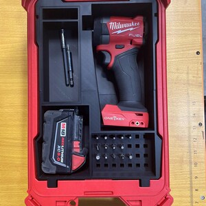 Peut inclure: Une visseuse à chocs Milwaukee Fuel avec technologie One-Key, une batterie M18 Redlithium XC5.0, deux porte-embouts et un jeu de forets organisés dans un insert en mousse noire à l'intérieur d'une mallette de transport rouge rigide.