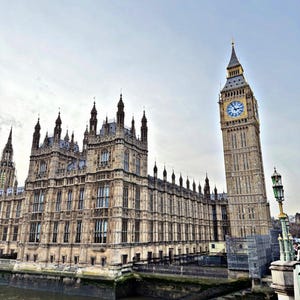 Könnte beinhalten: Der Palace of Westminster und der Elizabeth Tower, bekannt als Big Ben, stehen an der Themse. Das steinerne Gebäude zeichnet sich durch eine komplexe neugotische Architektur mit hohen Türmen, Spitzbogenfenstern und einem großen Zifferblatt aus.