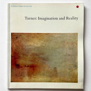 May include: A white book cover with the title "Turner: Imagination and Reality" and a red dot in the upper right corner. The book cover features a painting of a hazy, abstract landscape in shades of brown, yellow, and gray.