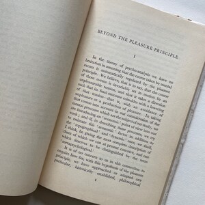 May include: A page from a book titled "Beyond the Pleasure Principle" by Sigmund Freud. The text discusses the theory of psychoanalysis and the role of the pleasure principle in mental events.