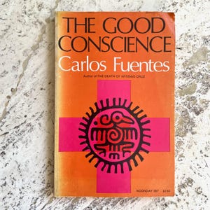 May include: A vintage paperback book titled "THE GOOD CONSCIENCE" by Carlos Fuentes. The cover is orange with a pink cross and a black and pink graphic. The book is a Noonday edition.