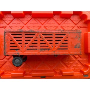 May include: An overhead shot of a vintage, rusty, red toy wagon with black wheels. The wagon has a slatted design and is set against a bright orange background. The wagon's metal shows signs of age and wear.
