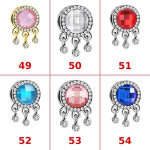 Op de afbeelding: Zes ronde bedels genummerd 49 tot en met 54. Elke bedel heeft een centrale gefacetteerde edelsteen omringd door een halo van kleine heldere kristallen, met drie bungelende kristallen accenten. Kleuren: roze, helder, rood, lichtblauw, donkerblauw.