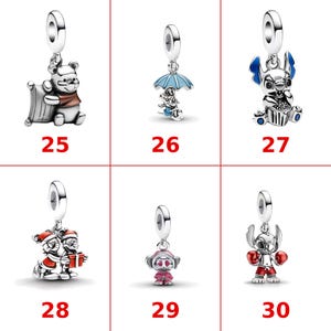 Op de afbeelding: Een verzameling van zes zilverkleurige metalen bedels met verschillende personages. De bedels bevatten Winnie de Poeh met een kussen, een personage onder een blauwe paraplu, Stitch die eet, twee personages met een cadeau, een roze personage en Stitch die bokst.