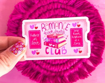 Peut inclure: Autocollant rose et blanc avec le texte "Romance Book Lovers Club" et une pile de livres avec des cœurs. L'autocollant contient également le texte "Falling in love" et "One book boyfriend at a time."