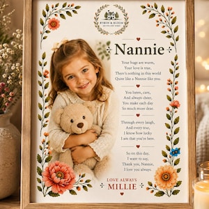 May include: A framed print featuring a photograph of a young child holding a teddy bear, surrounded by floral illustrations. The text reads: Nannie, Your hugs are warm, Your love is true, There's nothing in this world Quite like a Nannie like you.