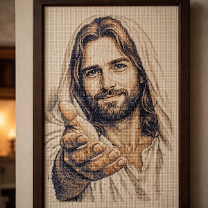 Pode incluir: Um bordado em ponto cruz emoldurado retratando o retrato de uma figura barbuda com cabelos longos, vestindo um manto com capuz. A figura é mostrada do peito para cima, estendendo uma mão para a frente em um gesto, em tons de marrom.