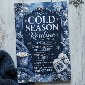 May include: A rectangular printable document titled The COLD SEASON Routine, featuring a blue background with white snowflakes, a mug of hot cocoa with marshmallows, and a pair of knit mittens. The text includes Winter Self Care Checklist.