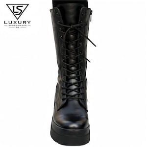May include: A black mid-calf lace-up boot featuring a thick platform sole, a side zipper closure, and black laces threaded through metal eyelets. The boot displays the logo LUXURY SPORTSWEAR PK in the upper left corner of the image.