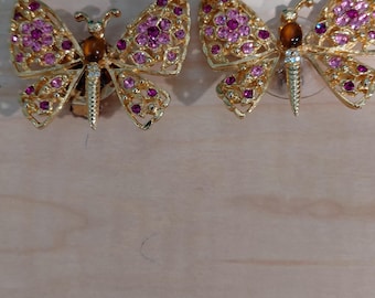 Vintage gold tone butterfly clip on earrings with pink rhinestones and a topaz colored cabochon