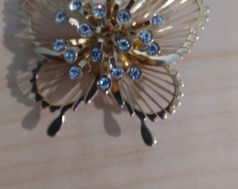 Vintage butterfly gold-tone filigree design brooch with wire wings and a cluster of clear rhinestones.