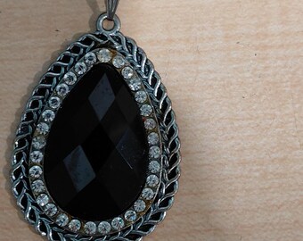 Vintage paparazzi necklace with black teardrop pendant accented by rhinestones in a silver frame