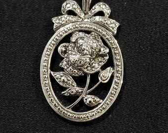 Vintage silver-toned rose pendant enclosed in oval frame