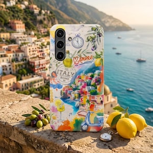 Op de afbeelding: Een telefoonhoesje met een kleurrijk aquarelontwerp van een Italiaanse kustplaats met een scooter, citroenen en olijven. De hoes heeft de woorden "Italy Rome 89" en "Amore". De hoes ligt op een stenen muur met citroenen en olijven.