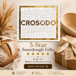 May include: A square white marble tile with a gold border and the text CROSODO in gold letters. Below, text reads 5-Star Sourdough Gifts, Perfect for Bakers & Bread Lovers, and SHOP ONLINE. A loaf of bread, wheat stalks, and a gift box are visible.