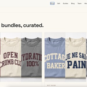 May include: A collection of six t-shirts in various colours including maroon, cream, and grey, each featuring bold, arched lettering with phrases such as LEVAIN SOCIETY, OPEN CRUMB CLUB, HYDRATION 100%, COTTAGE BAKER, JE NE SAIS PAIN, and CRUMB LIFE.