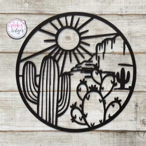May include: Black metal wall art featuring a desert scene with a sun, mountains, cacti, and prickly pear cactus.