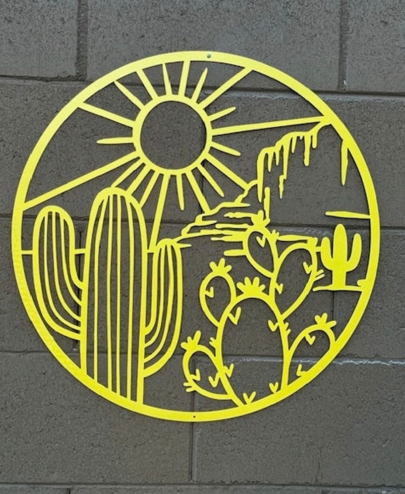 May include: Yellow metal wall art depicting a desert scene with a sun, cacti, and mountains. The art is circular and has a cutout design.