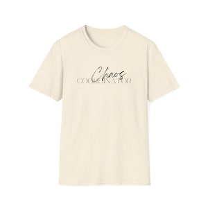 Könnte beinhalten: Cremefarbenes T-Shirt mit dem Schriftzug "Chaos Coordinator" in einer stilvollen Schreibschrift. Das Shirt hat einen klassischen Rundhalsausschnitt und kurze Ärmel. Der Stoff hat eine gesprenkelte Textur.