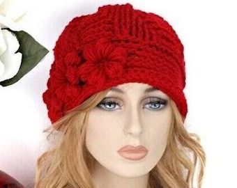 May include: A red crocheted beanie with a flower detail. The beanie is made of soft yarn and has a warm, cozy feel.