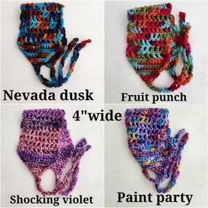 May include: Four crochet headbands, each 4 inches wide, in distinct colorways: Nevada dusk with dark blues and browns, Fruit punch with bright reds and greens, Shocking violet with purple gradients, and Paint party with a multicolored speckled pattern.