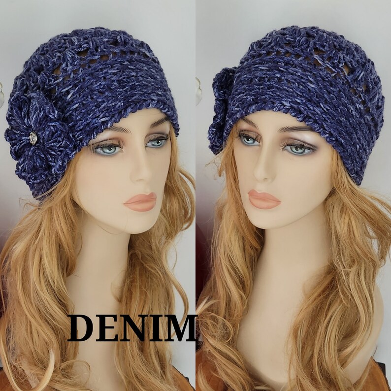 May include: A blue crocheted hat with a flower detail. The hat has a textured, slouchy design and is made with a soft yarn.