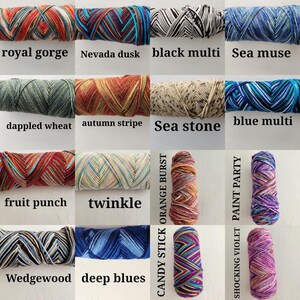 May include: A collection of sixteen skeins of yarn displayed in a grid, each featuring distinct color patterns and labeled with names including royal gorge, nevada dusk, black multi, sea muse, dappled wheat, autumn stripe, sea stone, blue multi, fruit punch, twinkle, candy stick orange burst, paint party, wedgewood, deep blues, and shocking violet.