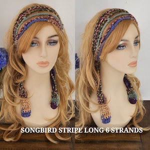 May include: A long, multi-colored crocheted headband with six strands. The headband is made in shades of purple, green, brown, and beige. The headband is tied in a knot at the back of the head and has long tassels hanging down the back.