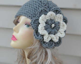 May include: A gray crocheted beanie with a large white crocheted flower on the side.