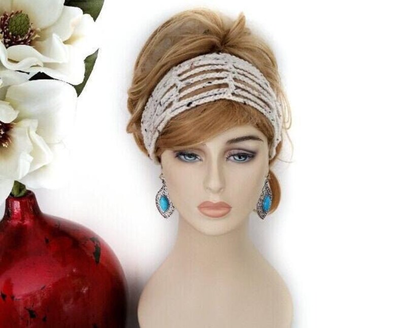 May include: A mannequin head with a cream-colored, open-weave headband and turquoise teardrop earrings. The earrings have a silver-colored metal frame. A red vase with white flowers is in the background.