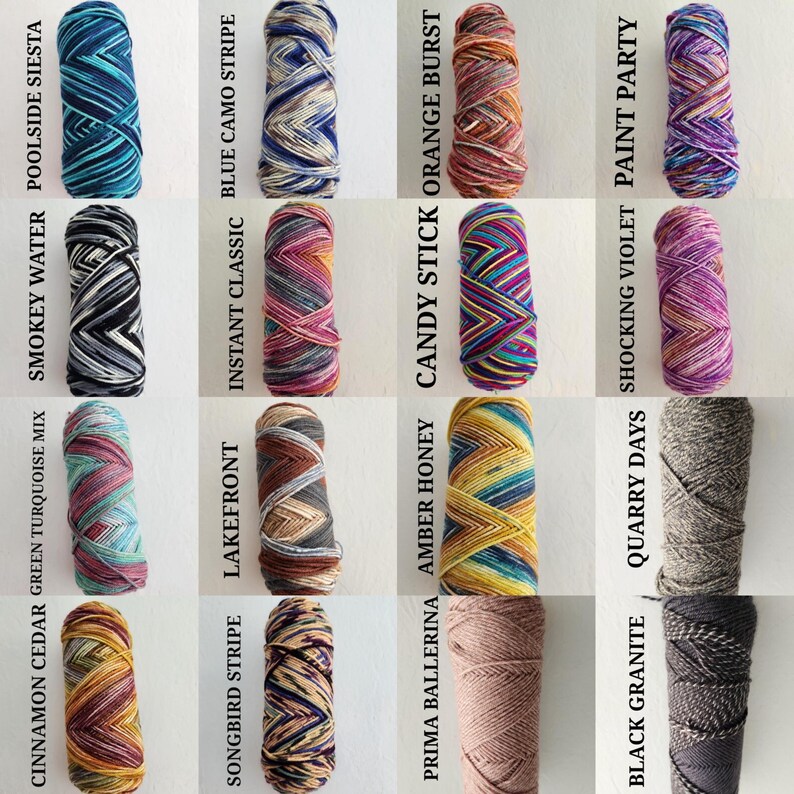 May include: A grid of sixteen skeins of yarn in various variegated and solid colors. Each skein is labeled with text including Poolside Siesta, Blue Camo Stripe, Orange Burst, Paint Party, Smokey Water, Instant Classic, Candy Stick, Shocking Violet, Green Turquoise Mix, Lakefront, Amber Honey, Quarry Days, Cinnamon Cedar, Songbird Stripe, Prima Ballerina, and Black Granite.