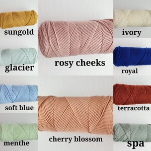 May include: A collection of yarn skeins in various colors, including sungold, glacier, soft blue, menthe, rosy cheeks, cherry blossom, ivory, royal, terracotta, and spa.