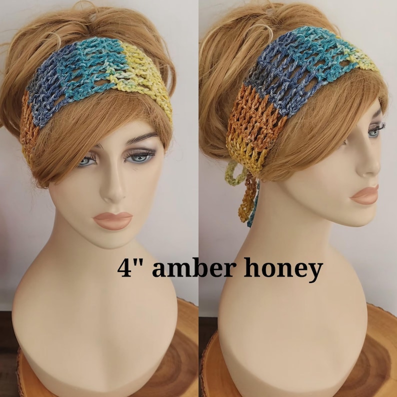 May include: A 4-inch wide crochet headband featuring a variegated color pattern of blue, teal, yellow, and amber honey tones. The accessory has an open, airy stitch design and includes tie-back strings for adjustment, displayed on a mannequin head.