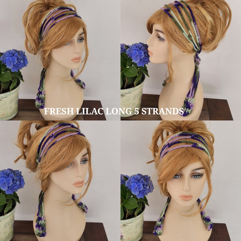 May include: A long, crocheted headband with five strands in shades of purple, green, and white. The headband is tied in a knot at the back of the head and hangs down the back.