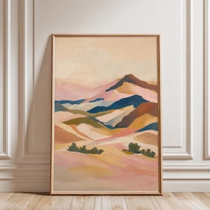 May include: A vertical rectangular wall art print featuring an abstract landscape painting with layered rolling hills in shades of dusty pink, muted orange, deep blue, and soft beige, accented by small dark green brushstrokes representing foliage.