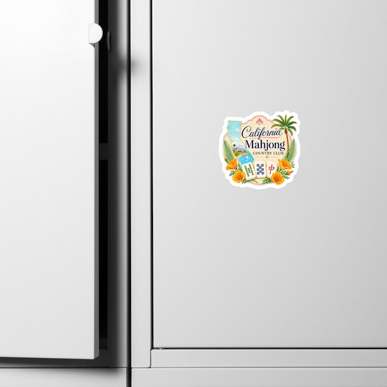 May include: A sticker featuring the text California Mahjong Country Club, a map of California, a palm tree, orange poppy flowers, and three mahjong tiles. The design is set against a light background with a decorative scalloped border edge.