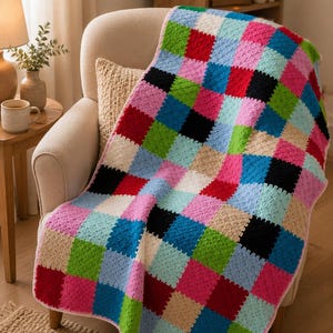 Puede incluir: Una manta de ganchillo hecha a mano con un vibrante patrón de tablero de ajedrez de cuadrados en colores alternos que incluyen rojo brillante, verde lima, azul cielo, negro, rosa suave y crema, con un borde de ganchillo en rosa claro.