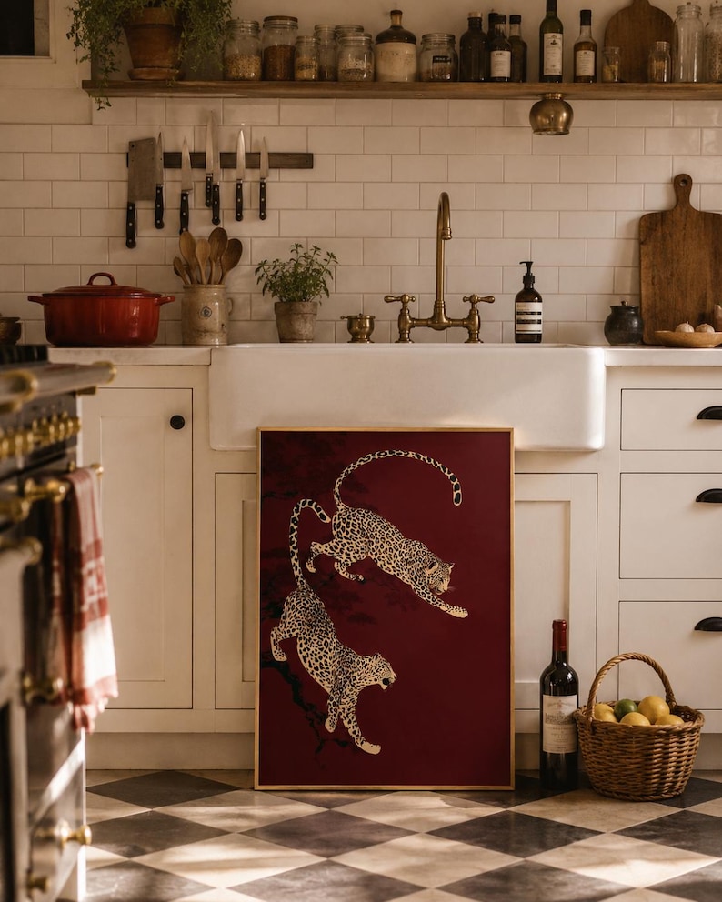 May include: A rectangular framed wall art piece featuring two leopards in a dynamic leaping pose against a deep burgundy background. The leopards are depicted with detailed black spots on a tan coat, positioned as if moving through dark tree branches.