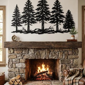 May include: A black metal wall art piece featuring a silhouette of five pine trees of varying heights. The design includes detailed branches and a textured ground line at the base of the trees, creating a continuous forest landscape scene.