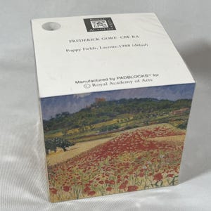 May include: A square paper block featuring the Royal Academy of Arts logo and the text Frederick Gore CBE RA, Poppy Fields, Lacoste, 1988 (detail). The sides display a colorful landscape painting of a field of red poppies under a cloudy sky.