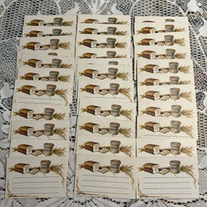May include: A collection of rectangular paper cards featuring a printed illustration of a loaf of bread, a small jar labeled HONEY, and wheat stalks. Each card includes blank horizontal lines for writing, arranged in a grid pattern.